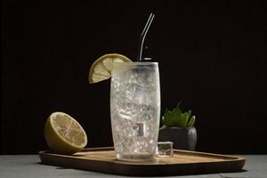 tom collins cocktail nel un' nero sfondo, eco-friendly metallo cannuccia foto