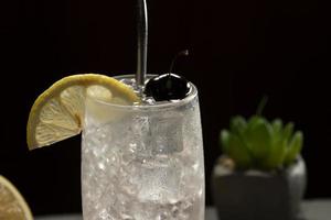 tom collins cocktail nel un' nero sfondo, eco-friendly metallo cannuccia foto