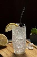 tom collins cocktail nel un' nero sfondo, eco-friendly metallo cannuccia foto