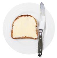 superiore Visualizza di coltello e pane e burro su piatto foto