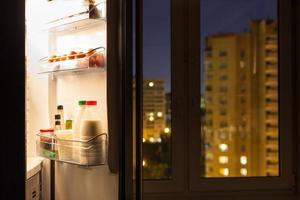 Aperto porta di frigorifero e urbano Visualizza nel notte foto