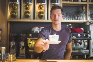 barista che offre caffè foto