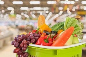 carrello pieno di frutta e verdura con supermercato negozio di alimentari sfocato sfondo sfocato con luce bokeh foto