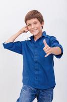 felice giovane ragazzo con chiamata gesto su sfondo bianco foto