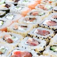 avvicinamento di un' lotto di Sushi rotoli con diverso ripieni. macro tiro di cucinato classico giapponese cibo. sfondo Immagine foto