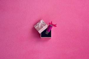 brillante rosa USB veloce memoria carta con un' rosa arco bugie nel un' piccolo regalo scatola nel rosa con un' piccolo arco su un' coperta di morbido e peloso leggero rosa vello tessuto. classico femmina regalo memoria carta design foto