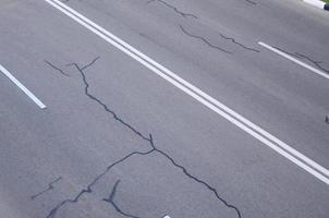 danneggiato cattivo asfalto strada con buche. toppa riparazione di asfalto foto