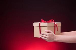 mano Tenere regalo scatola con allegro Natale e contento nuovo anno foto