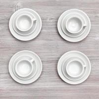 superiore Visualizza di quattro tazze e piattini su grigio tavola foto