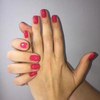 femmina mani con elegante rosso manicure su grigio sfondo foto