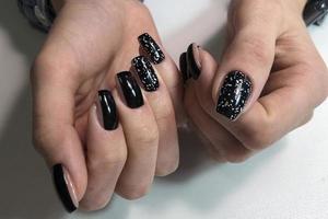 elegante di moda nero femmina manicure.mani di un' donna con nero manicure su Chiodi foto