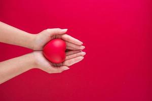 mano Tenere rosso cuore su carta sfondo con copia spazio per amore nozze o san valentino giorno foto