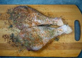 tacchino bacchette nel spezie menzogna su un' cucina taglio tavola. pollame carne. tacchino gamba. succoso carne è in attesa per essere cucinato. in attesa per il forno. foto