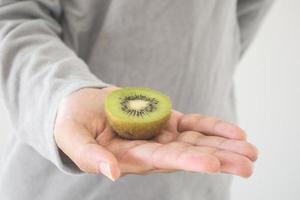 tenendo il kiwi fresco sulle mani foto