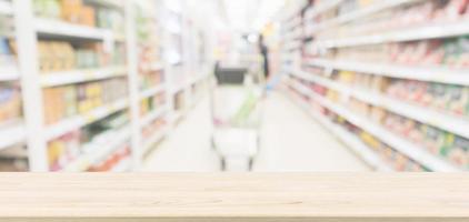 piano del tavolo in legno con sfondo sfocato corridoio del supermercato per la visualizzazione del prodotto foto