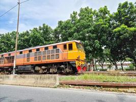 veloce arancia treno su rotaia nel bangkok. pesante diesel motore mezzi di trasporto industriale carico veicolo. foto