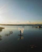 silhouette di un' uomo pesca nel il pomeriggio. tramonto su lago limbo, Indonesia foto