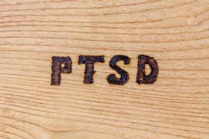 un abbreviazione ptsd - inviare traumatico fatica disturbo - bruciato di mano su piatto di legno tavola foto