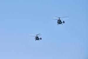 due elicotteri militari che volano nel cielo azzurro eseguendo un volo dimostrativo, squadra acrobatica foto