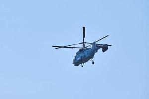 elicottero della marina che vola contro il cielo blu, copia spazio. un elicottero da guerra militare, vista laterale foto