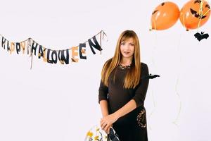 giovane donna con nero zucca nel Halloween decorazione foto