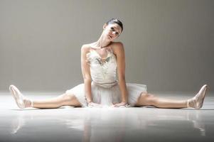 giovane bella ballerina strecthing gambe sul pavimento dello studio