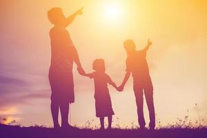 silhouette di un' contento famiglia e contento tempo tramonto foto