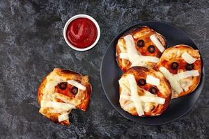 mini Pizza come mummia per bambini con formaggio, olive e ketchup. divertente pazzo Halloween cibo per bambini. foto