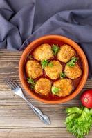 Polpette nel pomodoro salsa nel un' ciotola su di legno tavolo. foto