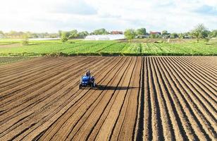 contadino su un' trattore coltiva terra dopo raccolta. meccanizzazione, sviluppo di agricolo tecnologie. macinazione allentamento aratura fatiscente suolo per ulteriore semina di coltivato impianti. foto