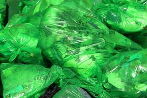 pieno telaio sfondo di verde plastica spazzatura borse con generico domestico rifiuto foto