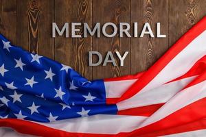 il parole memoriale giorno di cui con argento metallo lettere su di legno tavola superficie con spiegazzato Stati Uniti d'America bandiera foto