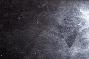 oleoso gloss nero acciaio superficie con molti le impronte digitali - avvicinamento con selettivo messa a fuoco foto