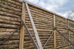 tradizionale di legno Casa pelato log parete durante co-strutturazione processi con diagonale oggetti di scena foto