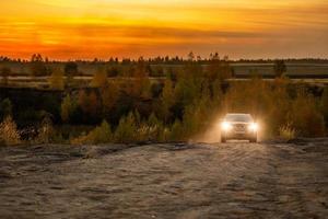 volkovo, Russia ottobre 4, 2020 blu nissan qashqai arrampicata su su sporco strada a autunno d'oro tramonto fuori strada. foto