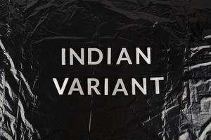 parole indiano variante di cui con argento metallo lettere su spiegazzato nero plastica Borsa sfondo foto