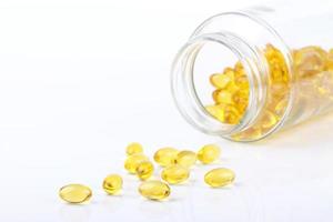 capsule vitaminiche versate dalla bottiglia foto