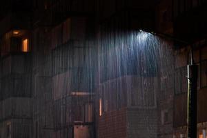 lampada inviare a piovoso notte con selettivo messa a fuoco e lungo esposizione movimento sfocatura di pioggia gocce foto