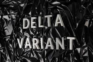 parole delta variante di cui con argento metallo lettere su spiegazzato nero plastica Borsa sfondo nel diagonale prospettiva foto