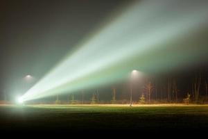 controluce proiettore o riflettore nel nebbioso notte parco foto