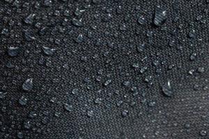 buio grigio impermeabile idrofobo stoffa avvicinamento con acqua gocce foto