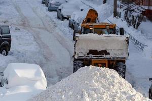 trattore rimozione neve a partire dal parcheggio vicino Residenziale edificio a inverno giorno foto