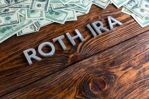 parole Roth ira di cui su di legno superficie di metallo lettere con noi dollaro banconote foto