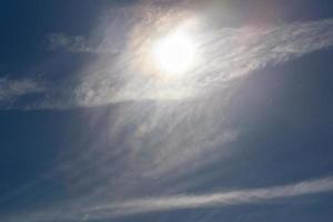 polvere particelle su blu cielo con sole e piuma nube a primavera giorno foto