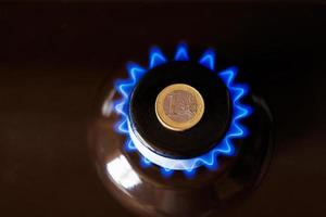 gas stufa bruciatore con uno Euro moneta di cui su superiore, ardente naturale gas con blu fiamma foto