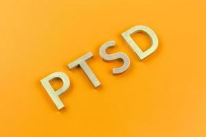 abbreviazione ptsd - inviare traumatico fatica disturbo - di cui con argento metallo lettere su giallo piatto superficie foto