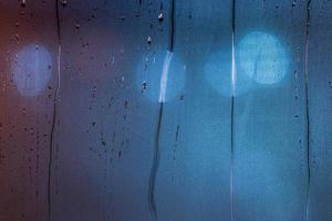 un astratto sfondo di notte bagnato finestra bicchiere con macchie nel blu tono gamma foto