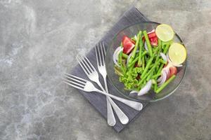 salutare cibo asparago insalata ha pomodoro cipolla lattuga nel ciotola su pietra sfondo. foto