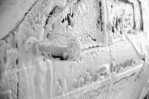 avvicinamento Visualizza di il motore auto con solido strato di sapone sud durante auto lavare. foto