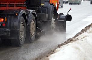 arancia strada pulizia camion con Filatura spazzole e lama a inverno giorno - avvicinamento con selettivo messa a fuoco foto